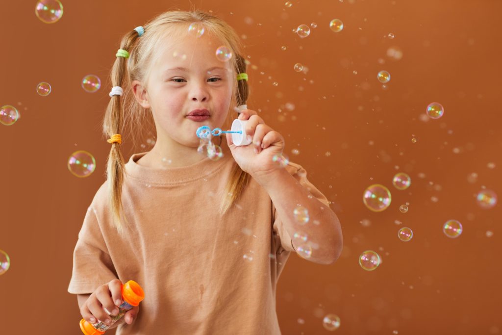 girl with down syndrome blowing bubbles
